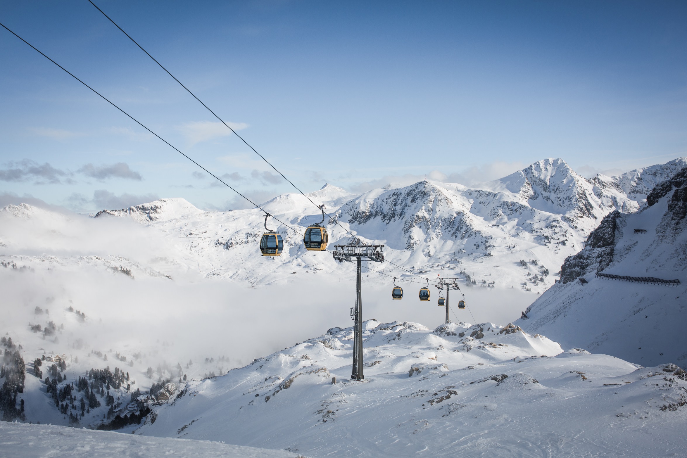 Winterpanorama der Skipisten in Obertauern mit Blick auf schneebedeckte Berge und Gondelbahn. ©TVB_Obertauern/Michael Kuschei