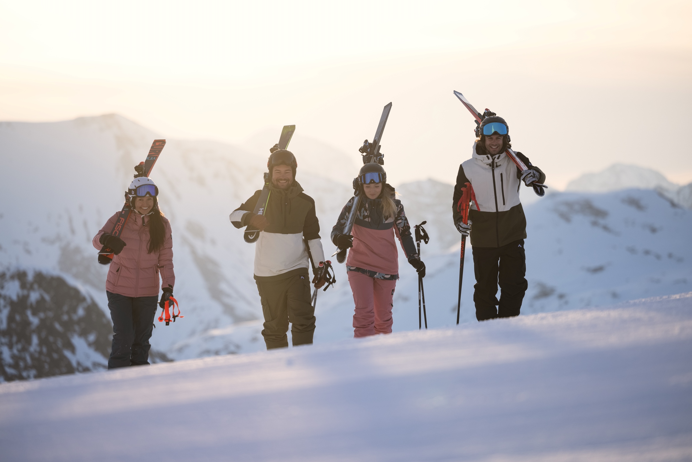 Vier Personen tragen Ski und gehen durch eine verschneite Berglandschaft. ©TVB_Obertauern