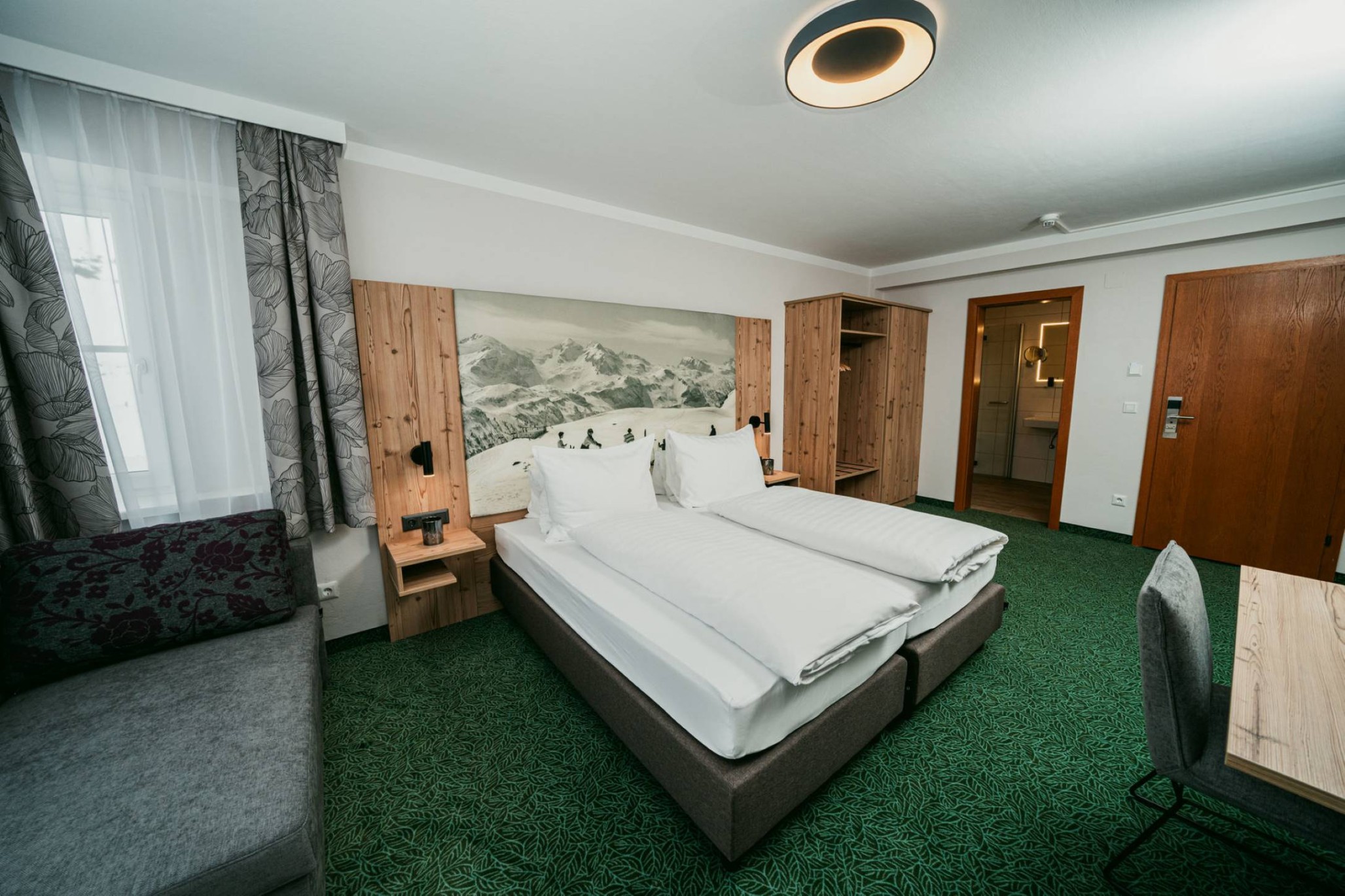 Modernes Hotelzimmer mit Doppelbett, Sofa und Badezimmer