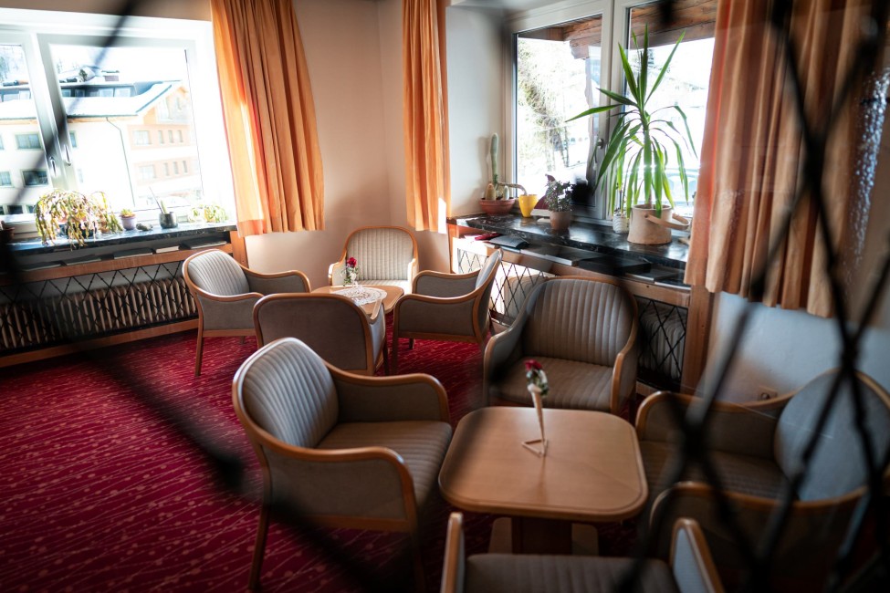 Ein gemütlicher Raum mit einem Tisch, Stühlen, Pflanzen und großen Fenstern