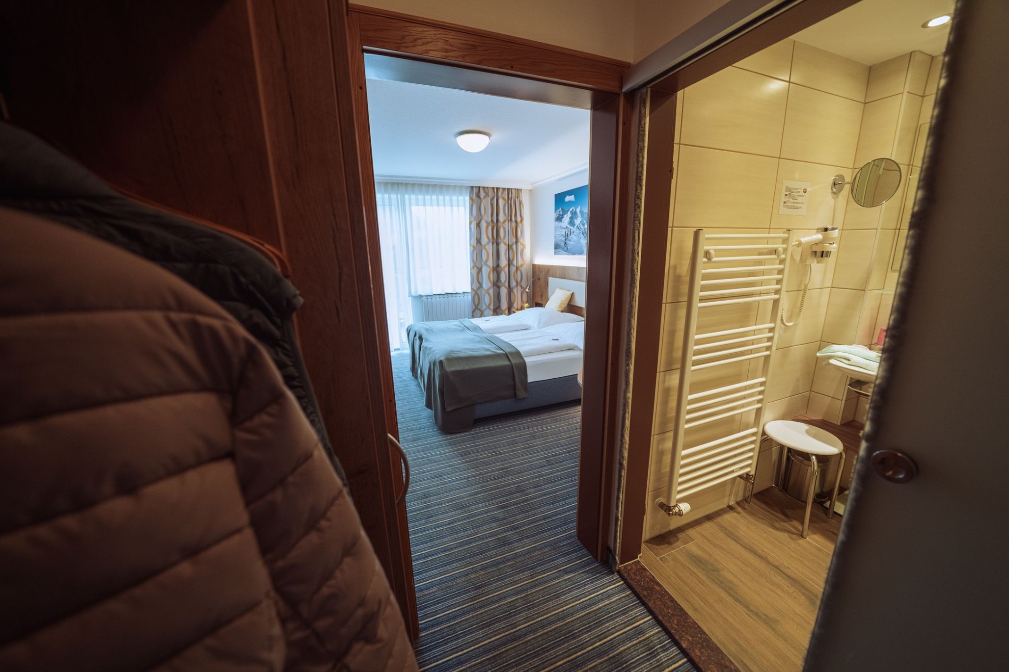 Blick in ein Hotelzimmer mit Doppelbett und angrenzendem Badezimmer