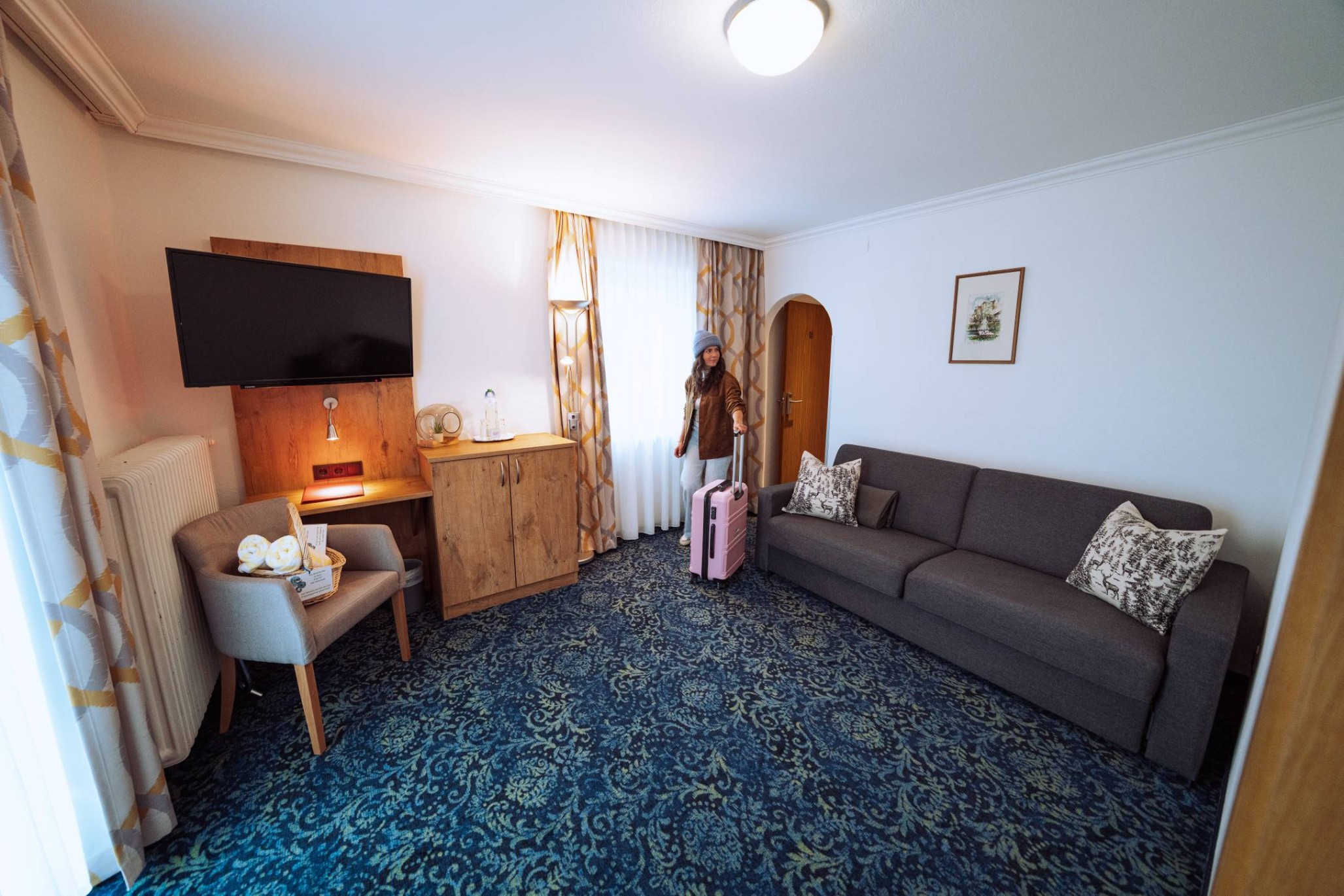 Eine Person in einem gemütlichen Zimmer mit einem rosa Koffer